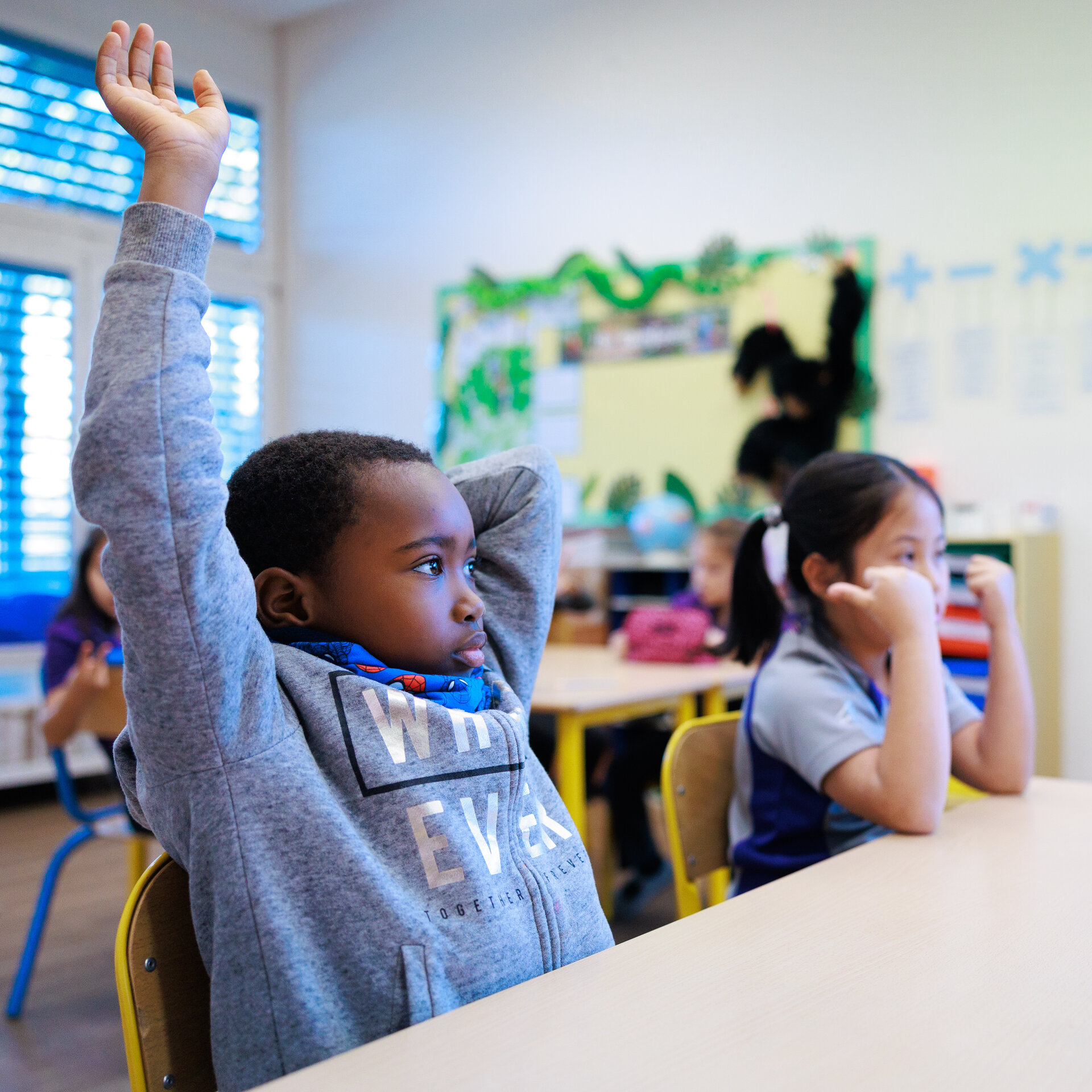 student raising hand in the classroom